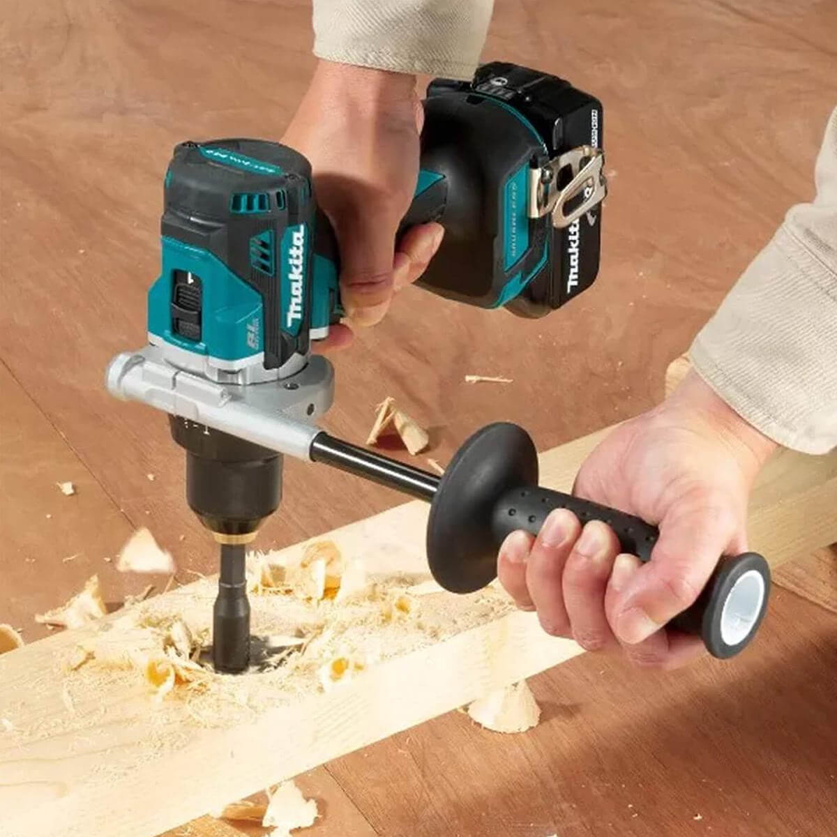 Person using a Makita cordless router on a wooden surface