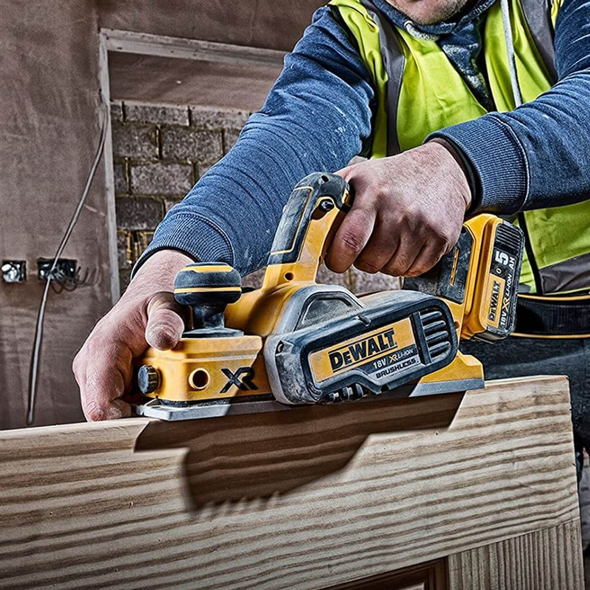 Person using a DeWalt power tool on a wooden surface