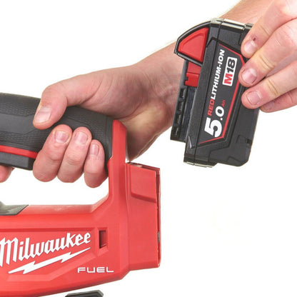 Hand holding a Milwaukee Jigsaw and battery  on a white background