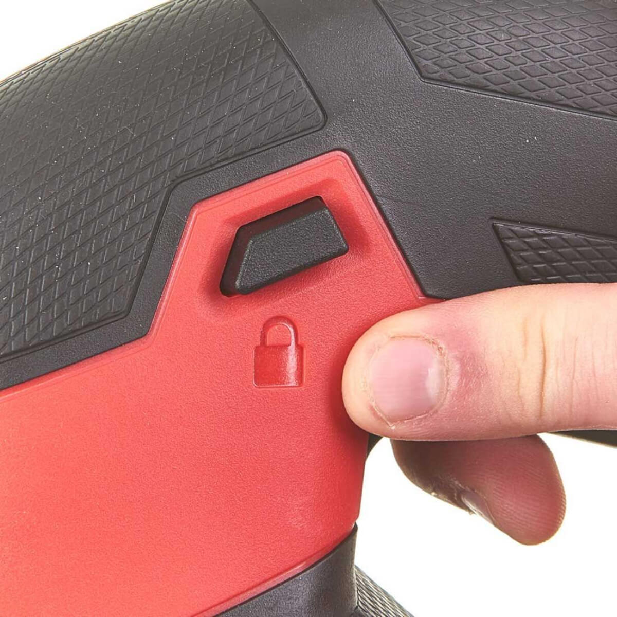 Close-up of a hand holding a red and black Jigsaw, presenting the locking button