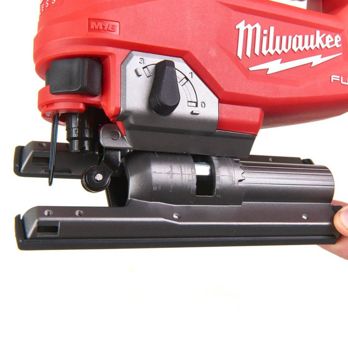 Red Milwaukee Jig saw held by a hand on a white background
