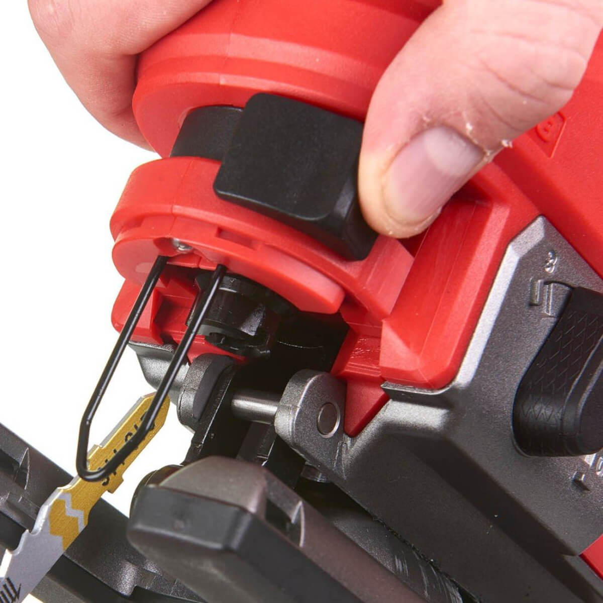 Close-up of a red Jigsaw with a hand holding it, focusing on the Blade lever