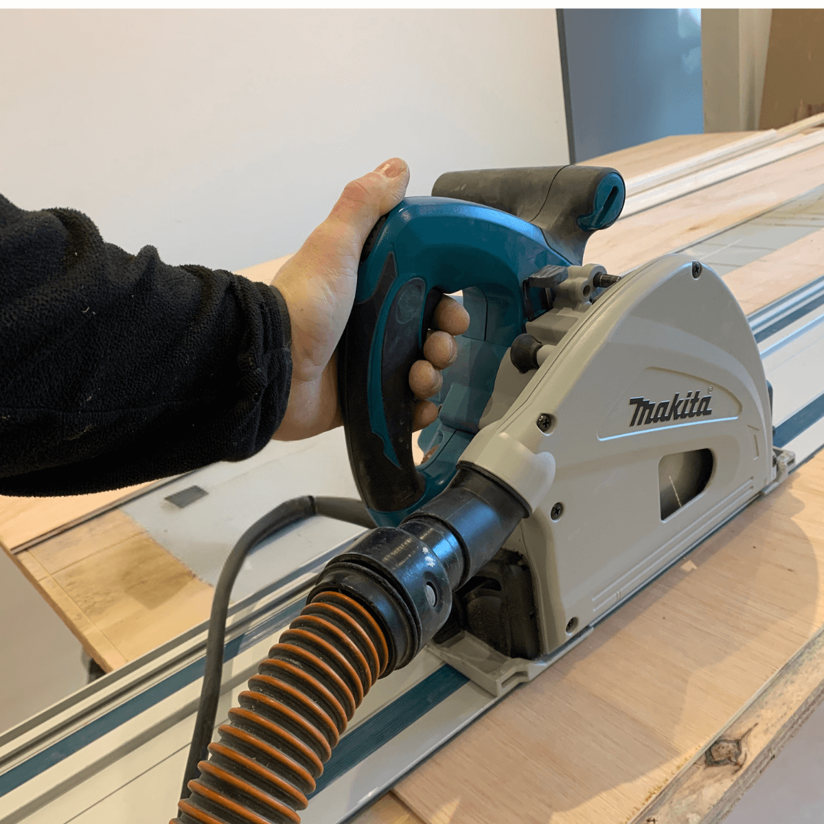 Person using a Makita Plunge saw on a wooden surface