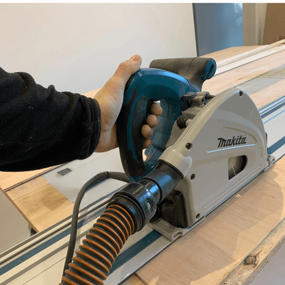 Person using a Makita Plunge saw on a wooden surface